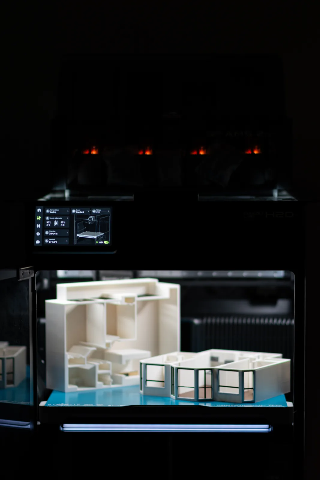 Two 3D printed architectural floor plan models inside the Bambu Lab H2D printer