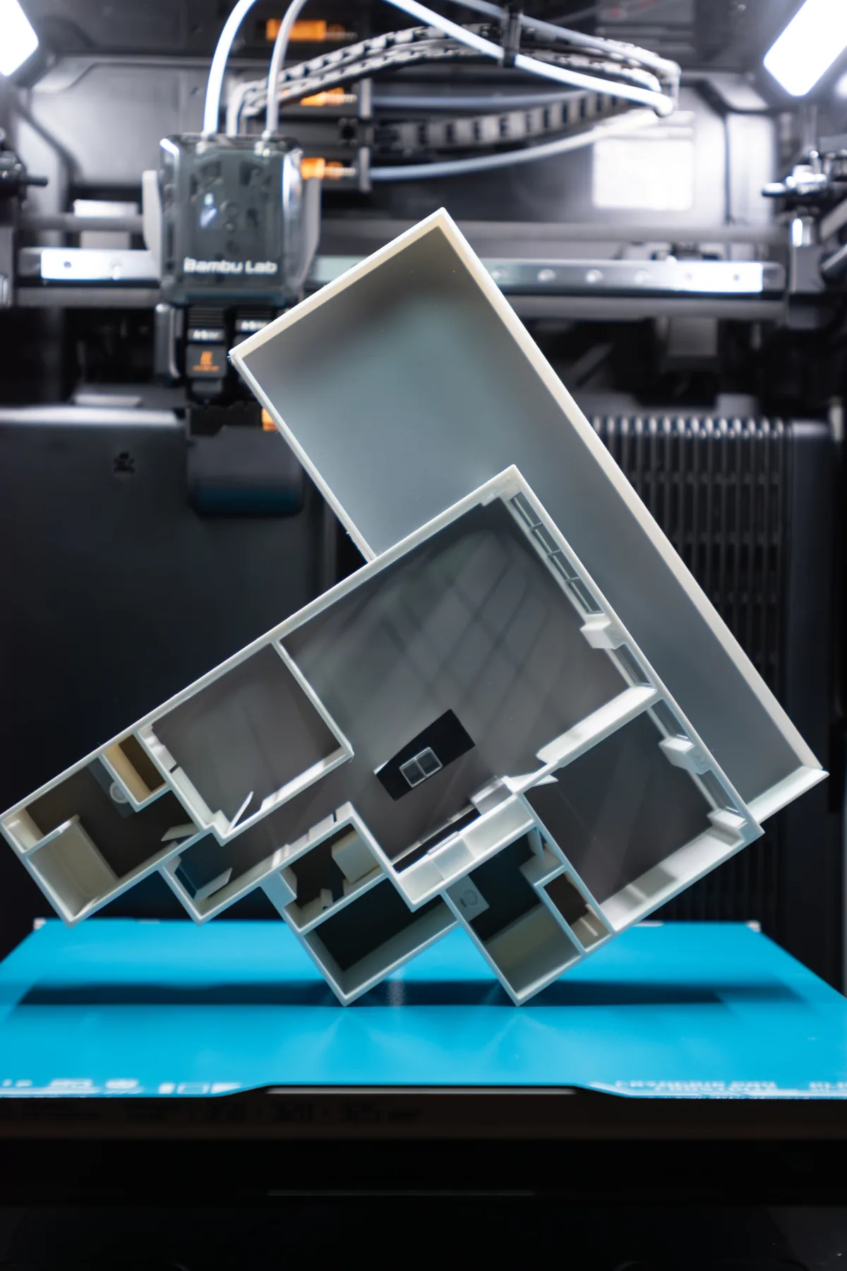 Side view of a 3D printed apartment floor plan model with its balcony section, inside the printer